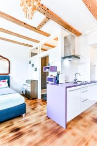 kuchnia z białymi szafkami i łóżko w pokoju w obiekcie A-Apartment w mieście Bad Säckingen