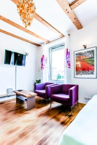 a living room with purple couches and a tv at A-Apartment in Bad Säckingen