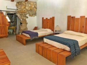two beds in a room with a stone fireplace at Finca Vallescondido in El Caobano