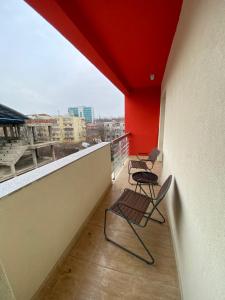 einen Balkon mit 2 Stühlen und einer roten Decke in der Unterkunft Renting Solutions Deluxe in Iaşi