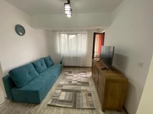 a living room with a blue couch and a tv at Renting Solutions Deluxe in Iaşi