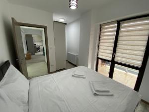 ein Schlafzimmer mit einem großen weißen Bett und einem Spiegel in der Unterkunft Renting Solutions Deluxe in Iaşi