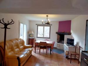 ein Wohnzimmer mit einem Sofa und einem Tisch in der Unterkunft Gîte au pays des lavandes in Aurel