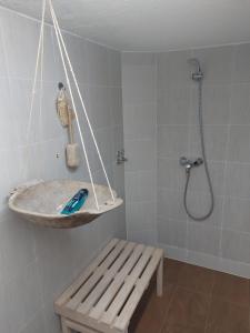 ein Bad mit einer Dusche, einer Bank und einem Waschbecken in der Unterkunft Villa Romantica in Novo Zvecevo