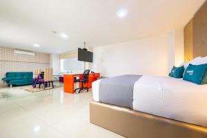 a bedroom with a large bed and a living room at Hotel MH Pereira in Pereira +23 photos