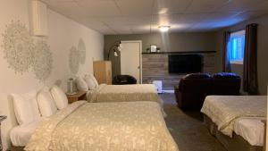 a hotel room with two beds and a flat screen tv at Motel Des Cascades in Baie-Saint-Paul