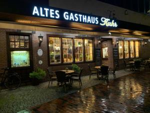 un restaurante con mesas y sillas frente a él en Altes Gasthaus Kuhr - Hotel & Restaurant, en Papenburg