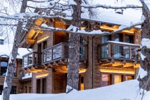 una casa en el bosque en la nieve en Chalet Imbosc'ché - 5 beautiful rooms in charming B&B en Livigno