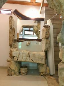 a bathroom with a large stone wall in a house at Finca Vallescondido in El Caobano