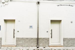 tres puertas en el lateral de un edificio blanco en Na Chicca e na Nicchia, en San Pancrazio Salentino