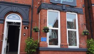 a red brick building with windows and plants on it at Bagshaw Bed & Breakfast in Bridlington