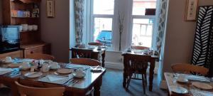 a dining room with tables and chairs and a window at Bagshaw Bed & Breakfast in Bridlington