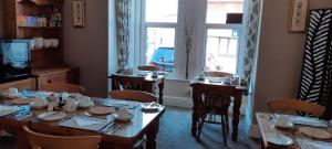 Un comedor con mesas y sillas y una ventana. en Bagshaw Bed & Breakfast, en Bridlington