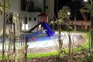 um parque infantil à noite com um escorrega azul em Apartamento na Praia Martim de Sá com linda vista em Caraguatatuba