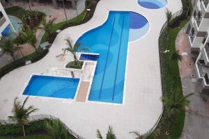 uma vista aérea de uma piscina em um resort em Apartamento na Praia Martim de Sá com linda vista em Caraguatatuba