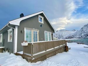 a house in the snow in front of a mountain at Fredvang Panorama Lofoten in Fredvang