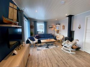 a living room with a blue couch and a tv at Fredvang Panorama Lofoten in Fredvang