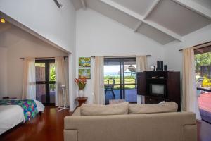 a living room with a couch and a bed and a television at Vai Villas in Avarua