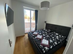 a bedroom with a bed with a black comforter at 3 Sosny Apartments - Suite 1 in Tatranska Strba