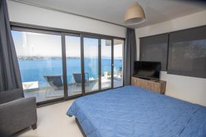 a bedroom with a blue bed and a large window at Raise Spetses Sea View Villa in Spetses