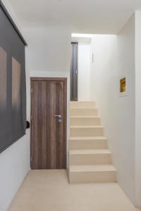 a staircase with a wooden door in a room at Raise Spetses Sea View Villa in Spetses