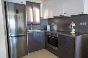 a kitchen with a stainless steel refrigerator and a sink at Raise Spetses Sea View Villa in Spetses