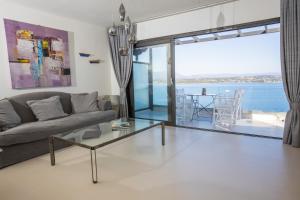 a living room with a couch and a glass table at Raise Spetses Sea View Villa in Spetses