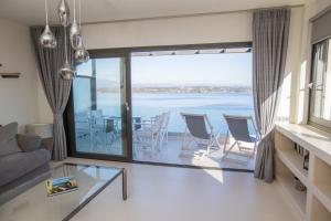 a living room with a view of the water at Raise Spetses Sea View Villa in Spetses