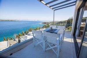 a balcony with a table and chairs overlooking the ocean at Raise Spetses Sea View Villa in Spetses