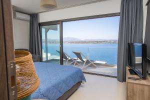 a bedroom with a bed and a view of the ocean at Raise Spetses Sea View Villa in Spetses