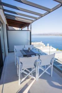 a table and chairs on a balcony with the ocean at Raise Spetses Sea View Villa in Spetses