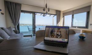 a laptop computer sitting on top of a wooden table at Raise Spetses Sea View Villa in Spetses