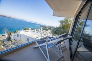 a balcony with two chairs and a view of the ocean at Raise Spetses Sea View Villa in Spetses
