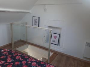 a room with a glass shelf and a bed at Gîte Le pt'i Baillis in Nismes