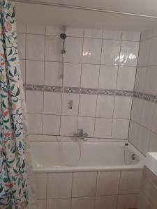 a bathroom with a bath tub with a shower curtain at Gîte Le pt'i Baillis in Nismes