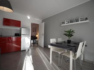 uma cozinha e sala de jantar com uma mesa preta e cadeiras brancas em Appartement dans le verdon em Allemagne-en-Provence
