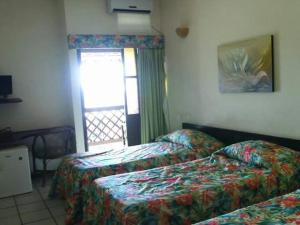 a hotel room with two beds and a window at Foz do Sauipe Eco Hotel in Porto de Sauipe