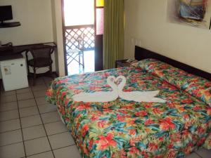 Dos cisnes pintados en una cama en una habitación de hotel en Foz do Sauipe Eco Hotel, en Porto de Sauipe