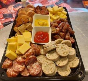 un plateau de différents types de fromage et autres denrées alimentaires dans l'établissement Aux trois petits cochons, à Hotton