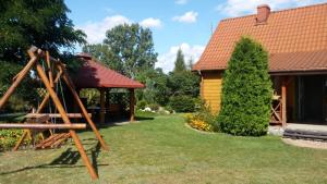 un patio con una casa y una estructura de madera en Bocianie Siedlisko, en Janowo