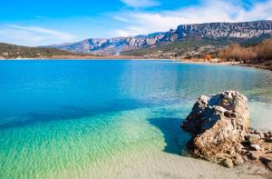 a large body of water with a rock in the water at Appartement dans le verdon in Allemagne-en-Provence