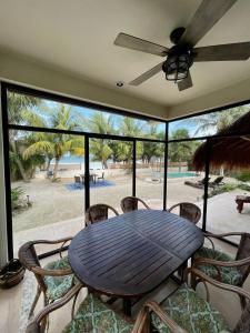a table and chairs on a porch with a view of the beach at Luxury Ocean Front Villa - Adults Only in Holbox Island