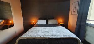 a small bedroom with a bed with two lights on it at La pépite du semnoz in Annecy +6 photos