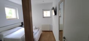 a white room with two beds and a window at Mundaka Sea Apartment in Mundaka