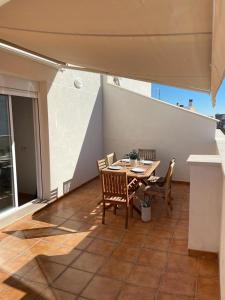 a patio with a table and chairs on a balcony at UIM Mediterraneo ATICO Poeta 7 Wifi in Puerto de Sagunto