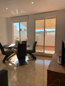 a living room with a table and chairs and a balcony at UIM Mediterraneo ATICO Poeta 7 Wifi in Puerto de Sagunto