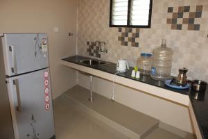 a kitchen with a sink and a refrigerator at Raj Residency Salem in Salem