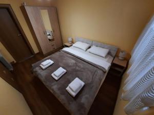 um quarto com uma cama grande e almofadas brancas em DION Kolašin em Kolašin