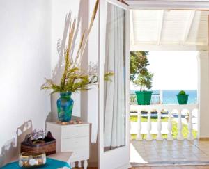 a room with a door open to a balcony with the ocean at Villa Elpida in Agios Georgios