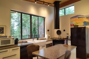 a kitchen with a large window and a table with chairs at Moon Dance Perch in Madeira Park